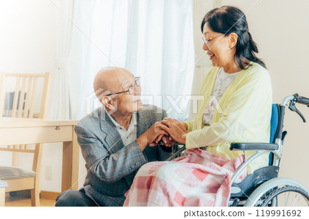 Senior woman sitting in a wheelchair, couple Senior woman sitting in a wheelchair, couple 119991692