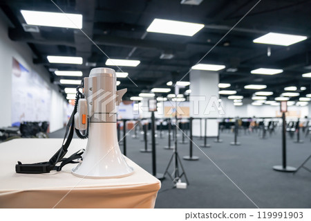 Two white - gray MEGAPHONE are laid on cream table in empty hall, ready to used for event corona virus vaccine booster in Bangkok, Thailand. Two white - gray MEGAPHONE are laid on cream table in empty hall, ready to used for event corona virus vaccine booster in Bangkok, Thailand. 119991903