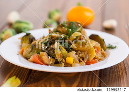 Brussel sprouts cooked with vegetables, on a wooden table Brussel sprouts cooked with vegetables, on a wooden table 119992547