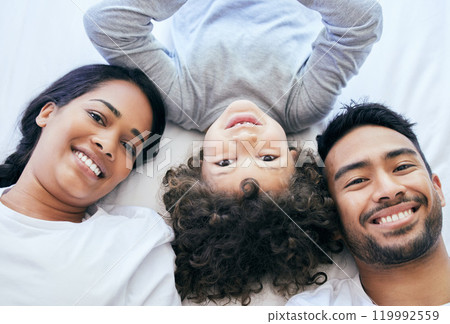 Top view, parents and son in portrait on bed, love and connection or security in home for bonding. Family, boy and relax in bedroom on morning for peace, wake up and together to support or rest Top view, parents and son in portrait on bed, love and connection or security in home for bonding. Family, boy and relax in bedroom on morning for peace, wake up and together to support or rest 119992559