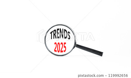 Planning trends 2025 new year symbol. Concept words Trends 2025 on beautiful white paper in magnifying glass. Beautiful white paper background. Business trends 2025 new year concept. Copy space. Planning trends 2025 new year symbol. Concept words Trends 2025 on beautiful white paper in magnifying glass. Beautiful white paper background. Business trends 2025 new year concept. Copy space. 119992656