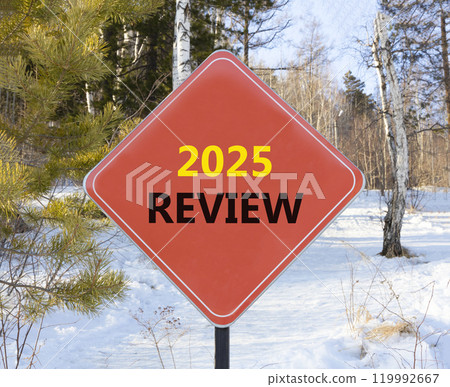 Planning 2025 review new year symbol. Concept words 2025 Review on beautiful red road sign. Beautiful winter forest background. Business 2025 review new year concept. Copy space. 119992667