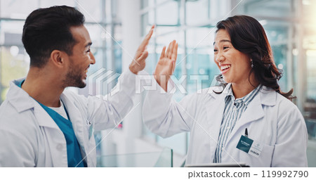 Doctors, man and woman with high five for teamwork, success and goals for healthcare services in clinic. People, partnership and celebration with cheers for achievement, results and smile in hospital Doctors, man and woman with high five for teamwork, success and goals for healthcare services in clinic. People, partnership and celebration with cheers for achievement, results and smile in hospital 119992790