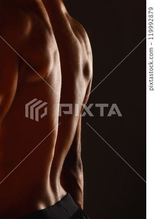 Back, fitness and man with muscles in studio for workout, sports and wellness or training. Bodybuilder, athlete and sportsman with progress, results and spine by black background for aesthetics 119992879