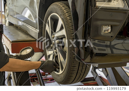 Automobile repair shop - checking tire pressure 119993179