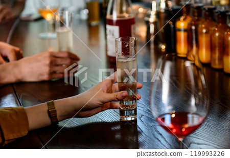 Image of a man and woman drinking wine at a bar counter 119993226