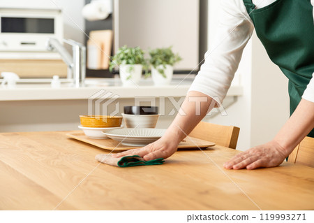 一名中高級婦女清理碗碟並擦桌子 一名中高級婦女清理碗碟並擦桌子 119993271