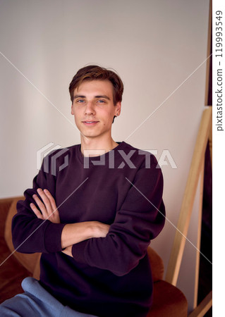 portrait of an attractive young 20 year old man with dark hair and blue eyes, studio photo shoot 119993549