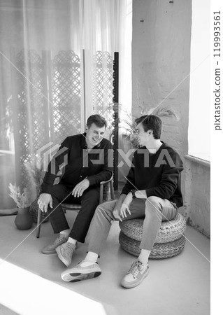 middle-aged father talking and laughing with his young son 119993561