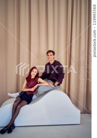 siblings, young  brother and teenage sister posing together, studio photo shoot 119993568