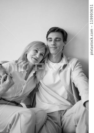 middle-aged mother hugs grown-up son 119993651