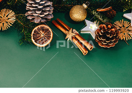 Christmas background. Green twigs with Christmas golden bulbs on green background Christmas background. Green twigs with Christmas golden bulbs on green background 119993920