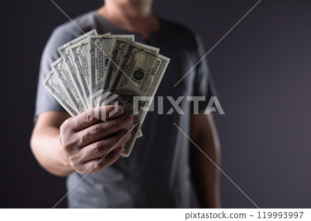 business man holding 100 cash bills Dollar currency, investment finance concept, success in business. 119993997