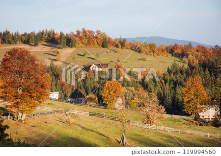 mountainous rural landscape of romania in autumn. village in the valley on a sunny evening. transylvania scenery in fall season. authentic environment 119994560
