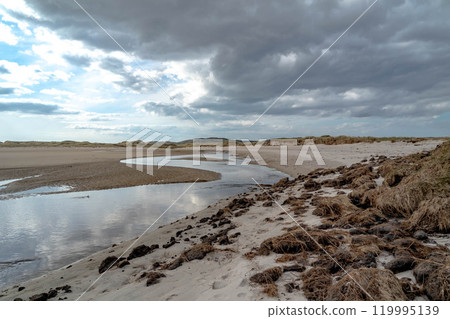 The stream that flows from Sheskinmore Nature Reserve to Ballinravey Strand between Ardara and Portnoo in Donegal - Ireland 119995139