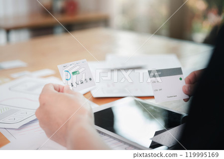 UX or UI designers designing on digital tablet and smartphone application layout prototype project. UX or UI designers designing on digital tablet and smartphone application layout prototype project. 119995169