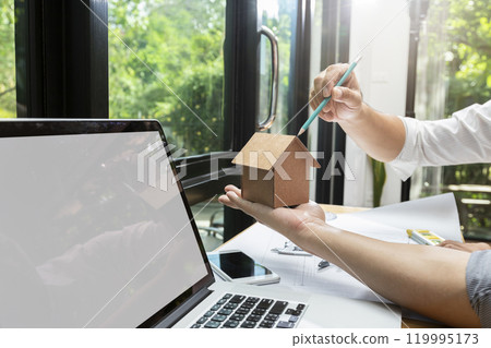 Confident team of architect working together in a office.They discussing about new startup project on desk. Architect discuss with engineer about project in office, architectural concept Confident team of architect working together in a office.They discussing about new startup project on desk. Architect discuss with engineer about project in office, architectural concept 119995173