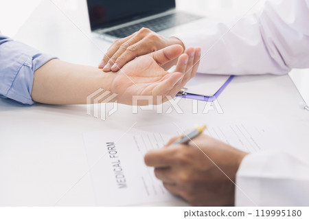 Doctor examining patient pulse by hands. Healthcare and medical service. 119995180