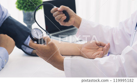 Doctor measuring blood pressure of the patient with sphygmomanometer in the hospital, Medical and health care concepts. 119995182