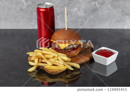 Burger on a wooden board with a patty, tomato, cheese, cucumber and lettuce. Burger on a wooden board with a patty, tomato, cheese, cucumber and lettuce. 119995453