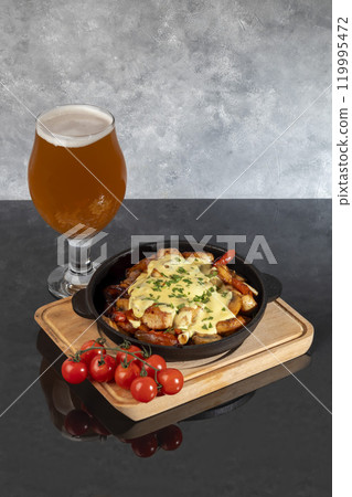 Stewed chicken, onions, potatoes and various vegetables in a cast iron skillet. 119995472