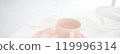 Tender pink mug on light background. Ceramic coffee cup for montage or design. 119996314