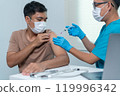 Doctor Administering Vaccine Injection to Patient's Arm in Medical Setting 119996342