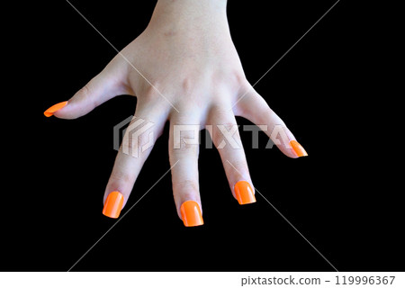 Girl's hands with orange false nails on a black background. female manicure Girl's hands with orange false nails on a black background. female manicure 119996367