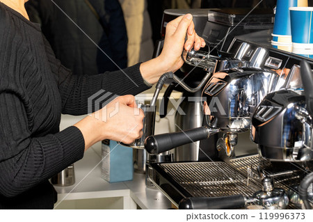 Crafting the perfect espresso in a bustling cafe during the morning rush hour. 119996373
