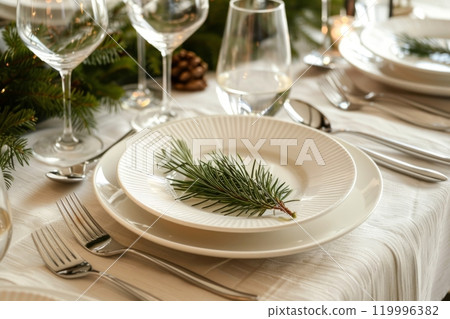 A modern Christmas dinner table setting features minimalistic decor with elegant white plates, silver cutlery, and fresh greenery accents, creating a chic and refined holiday atmosphere A modern Christmas dinner table setting features minimalistic decor with elegant white plates, silver cutlery, and fresh greenery accents, creating a chic and refined holiday atmosphere 119996382