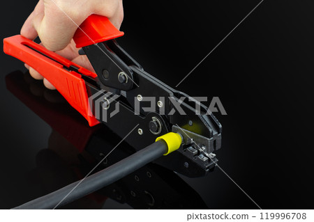 Close Up of Hand Using Cable Crimper Tool 119996708