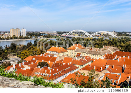 cityscape of Novi Sad from the historic vantage point of Petrovaradin, where ancient towers and charming streets intertwine with the gentle flow of the Danube. High quality photo 119996889