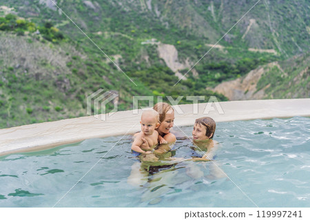 Mother with her toddler and teenage sons bathing in the hot springs of Grutas Tolantongo, Mexico. Family adventure, relaxation, and natural wellness concept Mother with her toddler and teenage sons bathing in the hot springs of Grutas Tolantongo, Mexico. Family adventure, relaxation, and natural wellness concept 119997241