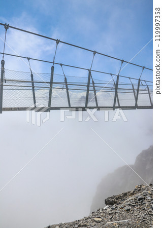 Titlis suspension bridge of steel crossing the peak on top of Titlis glacier in the Uri Alps, Engelberg, Switzerland. Highest suspension bridge in Europe 119997358