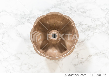 Flat lay. Greasing a bundt cake pan with vegetable shortening, preparing to bake a delightful homemade pumpkin bundt cake. Flat lay. Greasing a bundt cake pan with vegetable shortening, preparing to bake a delightful homemade pumpkin bundt cake. 119998194