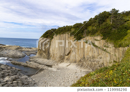 Rocks of Stolbchaty. landscape with columnar basalt lavas rocks forming a natural geometric pattern. Geographic cape on the east shore of Kunashir Island of Sakhalin Oblast, Russia. Mendeleyev volcano 119998298