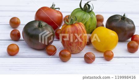 Variety of colorful tomatoes on the white wooden rustic table. Variety of colorful tomatoes on the white wooden rustic table. 119998416