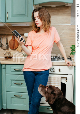 young woman is chatting on smartphone and ordering food from a delivery service or restaurant.  119998911