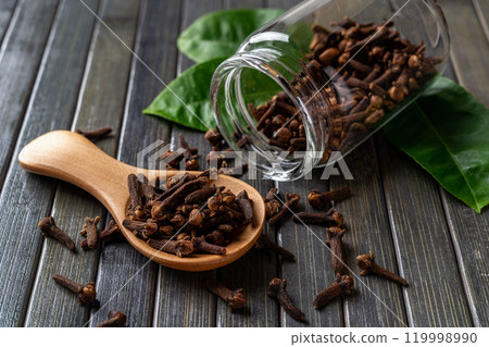 Dry clove buds in a light wooden spoon macro. 119998990