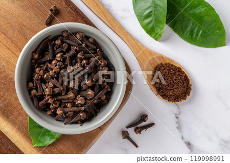 Cloves spice whole and ground over marble background. Cloves spice whole and ground over marble background. 119998991