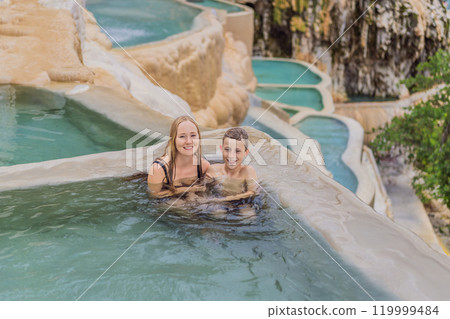 Mother with her toddler and teenage sons bathing in the hot springs of Grutas Tolantongo, Mexico. Family adventure, relaxation, and natural wellness concept 119999484