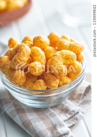 Puffed crispy Peanut flips in bowl on white table. 119999682