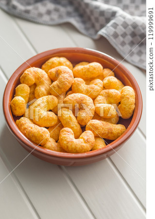 Puffed crispy Peanut flips in bowl on white table. 119999691