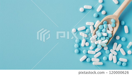 heap of medical pills and drugs in capsules in spoon on blue background, healthcare and medicine pharmacy background 120000626
