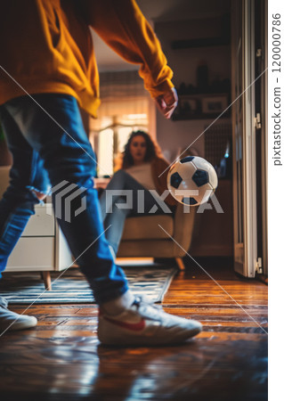 husband playing soccer with wife at home, man play football with woman at living room, person kick ball husband playing soccer with wife at home, man play football with woman at living room, person kick ball 120000786