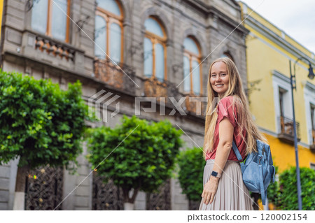 Female tourist walking through the colorful colonial streets of Puebla, Mexico. Travel, cultural exploration, and vibrant architecture concept 120002154