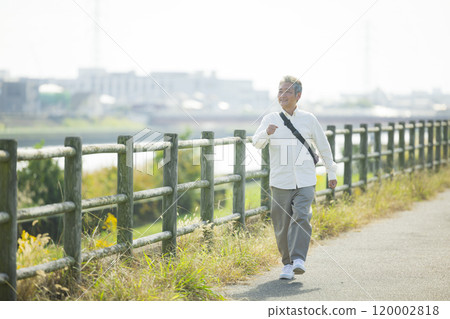 Seniors walking energetically along the bank 120002818