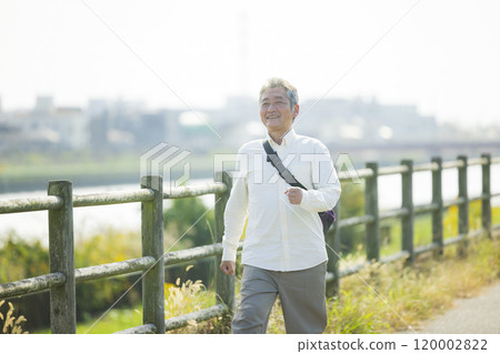 Seniors walking energetically along the bank 120002822