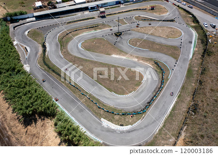 Drone rotating over go-karts racing on winding Drone rotating over go-karts racing on winding 120003186