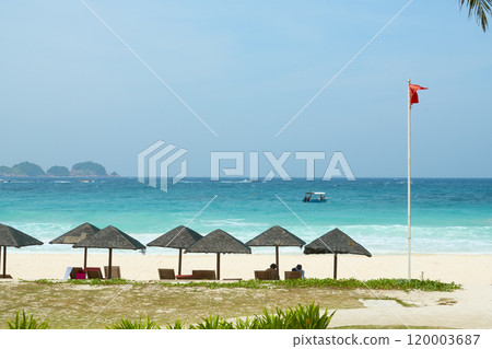 Tourists relaxing under thatched umbrellas on redang island beach Tourists relaxing under thatched umbrellas on redang island beach 120003687